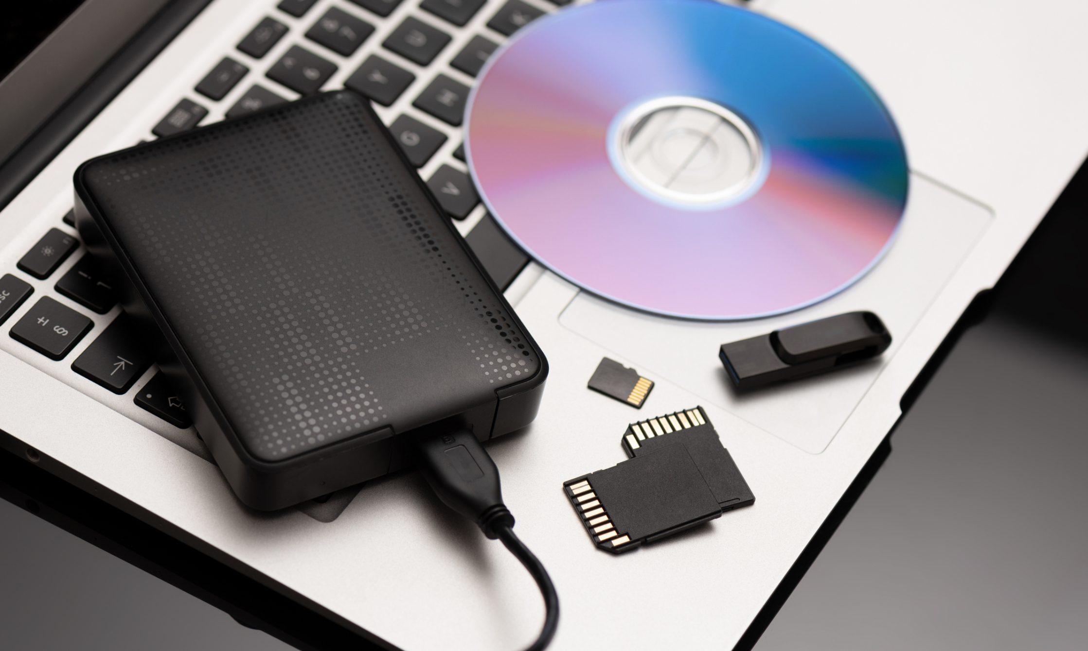 External hard drive and CD on laptop.
